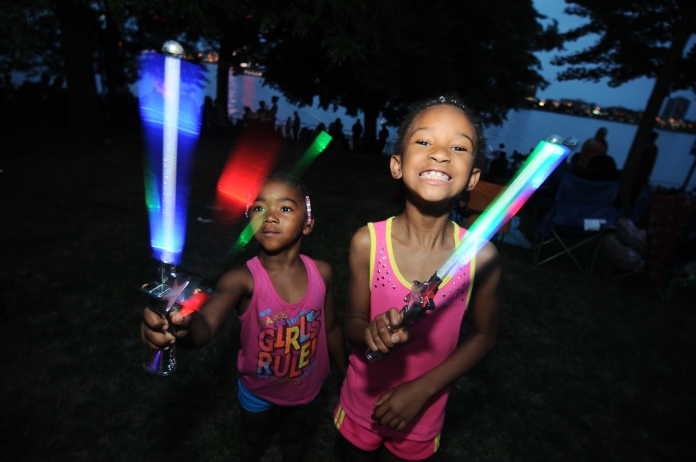(left) Sayniya, 4, and Kynoriana, 8 of Detroit, play with glow wands ahead of Monday night's annual firework display in Hart Plaza, June 23. (Tanya Moutzalias/Special to the Detroit News)