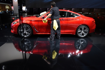 A worker clean the 2017 Infiniti Q60 Sports Coupe. Thousands of visitors attend the 2016 North American International Auto Show for Ôfamily dayÕ on Friday at Cobo Center in Detroit, Jan. 22, 2016. (Tanya Moutzalias | MLive Detroit)